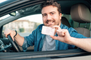 photo of a man holding his reinstated license