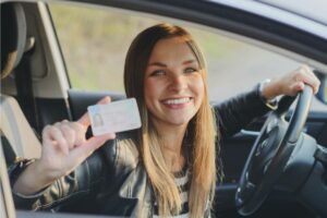 woman holding a drivers license after denied license reinstatement