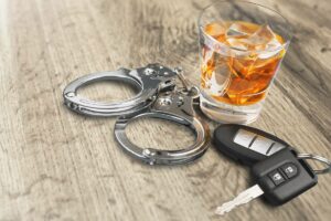 keys and handcuffs next to a drink after dui license renewal