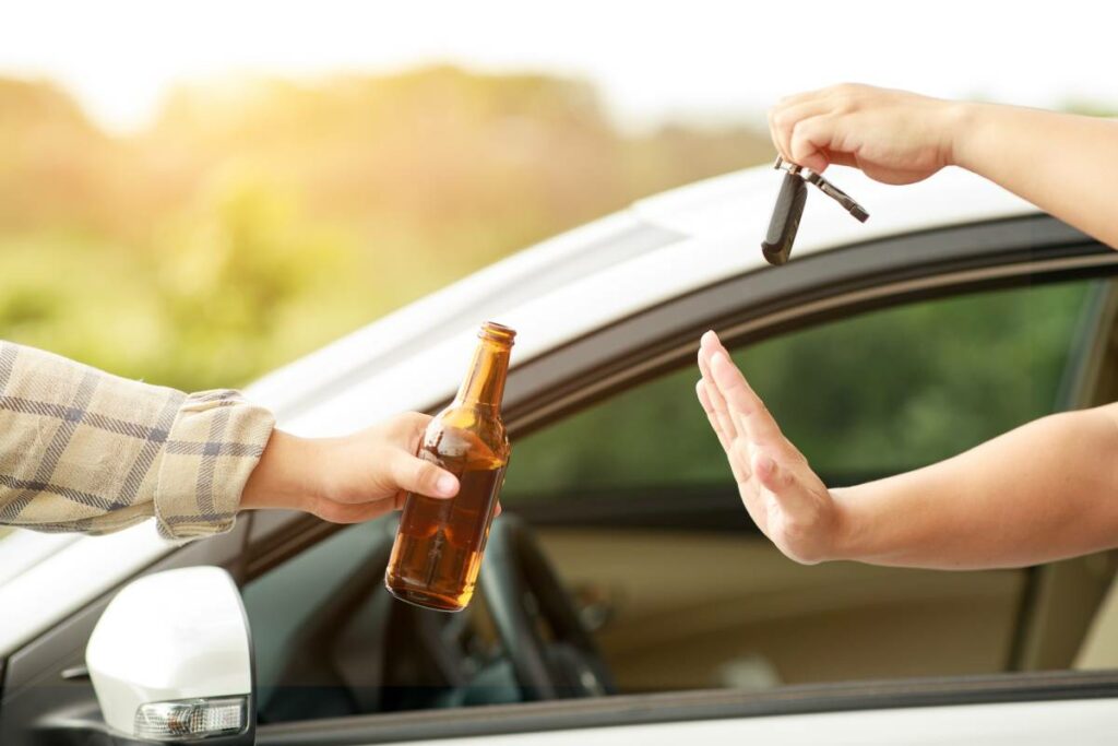 A driver holding their keys and saying no to a beer