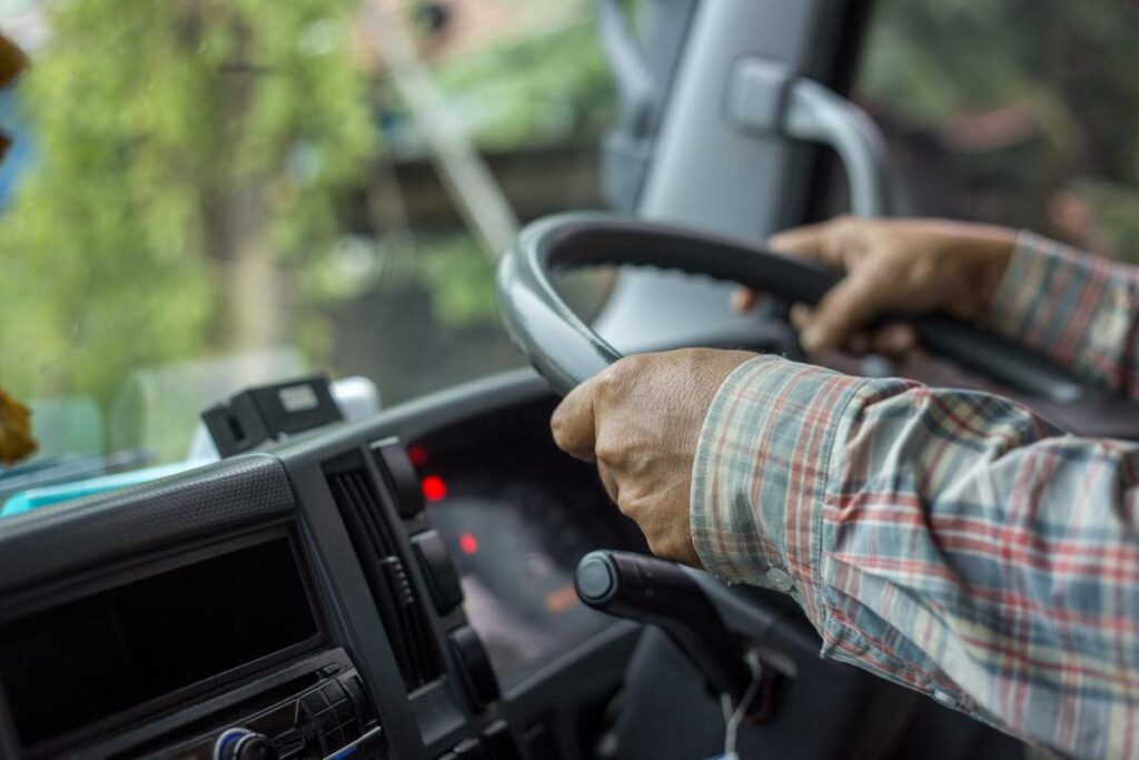 Person holding the steering wheel of a commercial vehicle