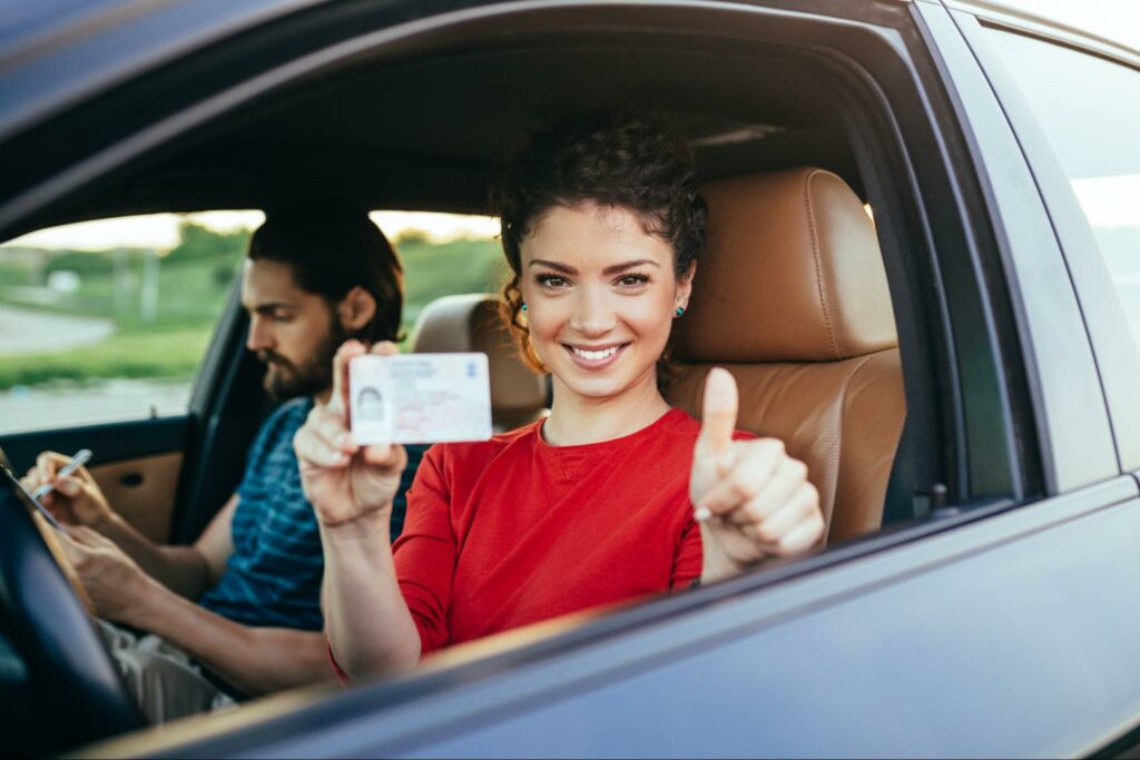woman in a car showcasing her drivers license
