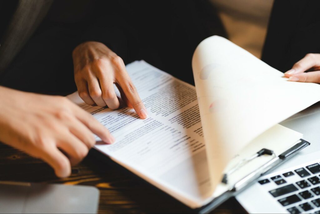 Attourney looking at a stack of documents with a client