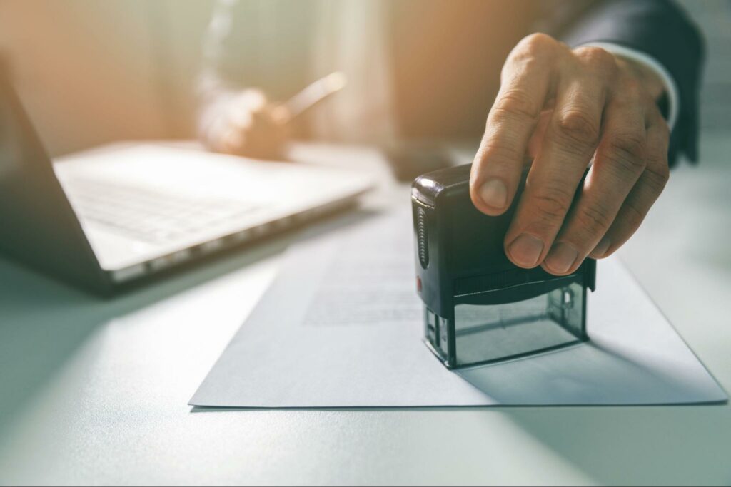 Person stamping a document with approval